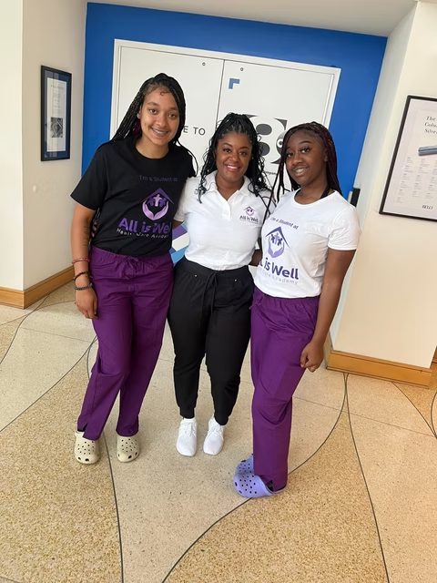 Three students in All is Well shirts